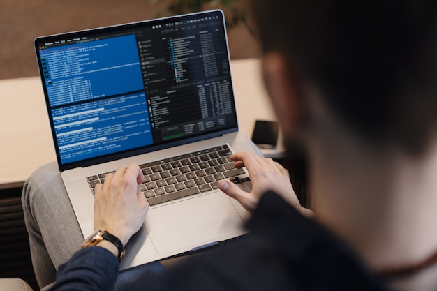 Close up man writing code on the laptop Free Photo